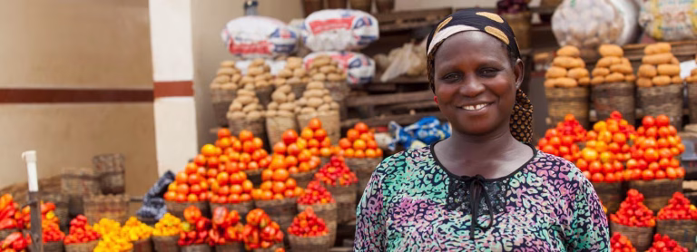 Woman posing in front of fruit stall