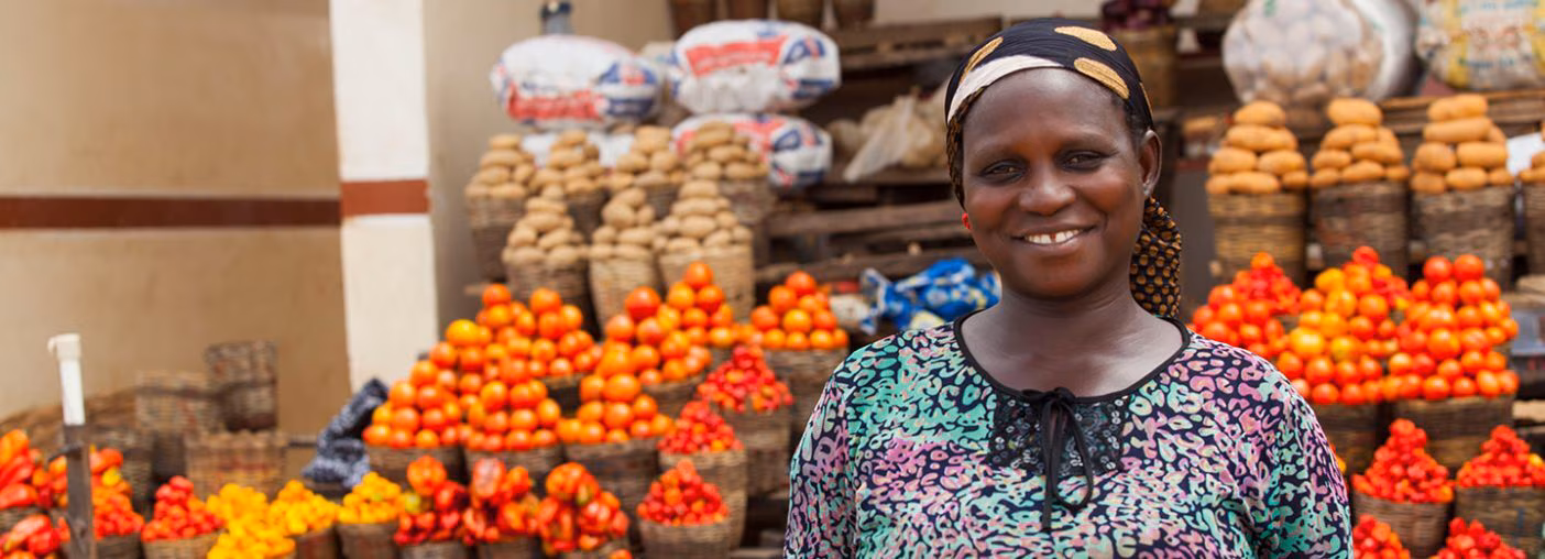 Woman posing in front of fruit stall