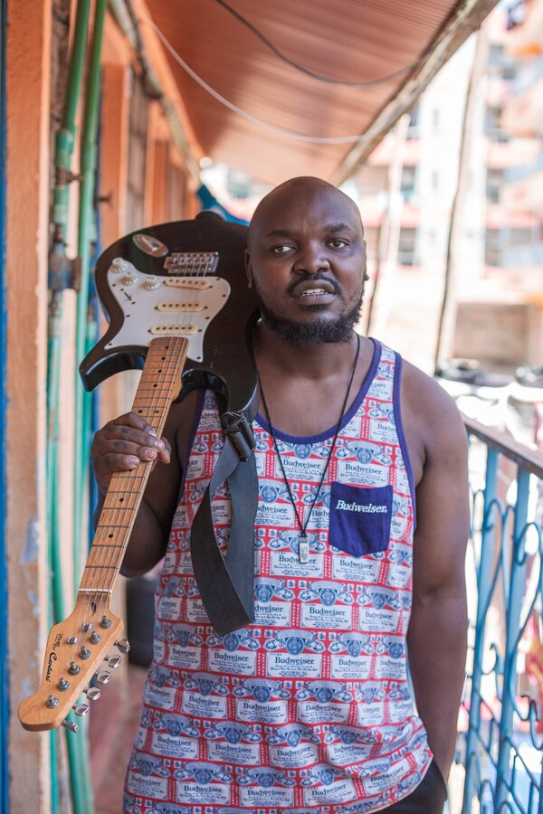 James with guitar on shoulder posing