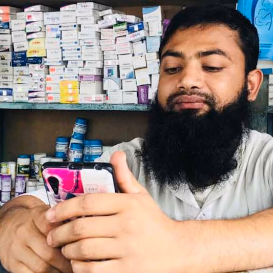 Pharmacist holding phone at desk