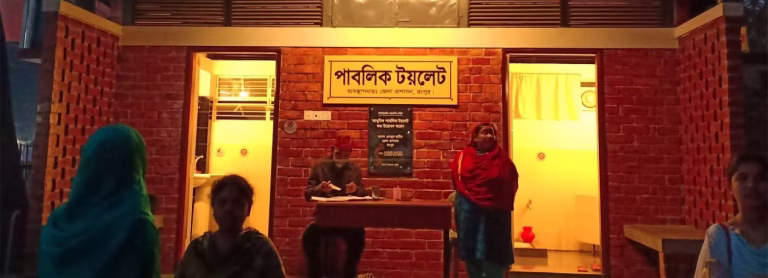 People stand outside of toilet building