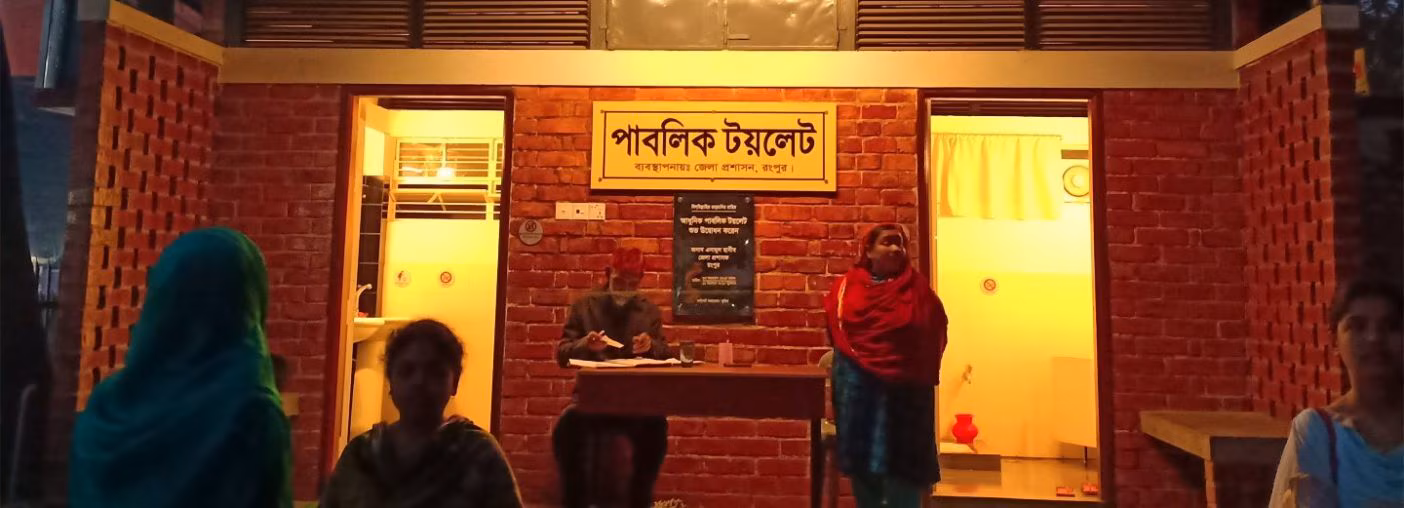 People stand outside of toilet building