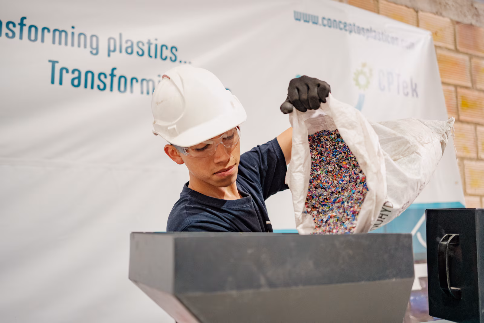 Young man pouring pellets into a hopper